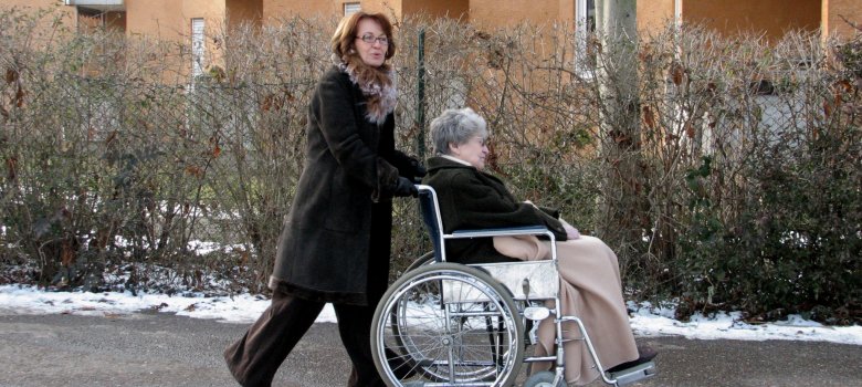 Frau schiebt Rollstuhlfahrerin