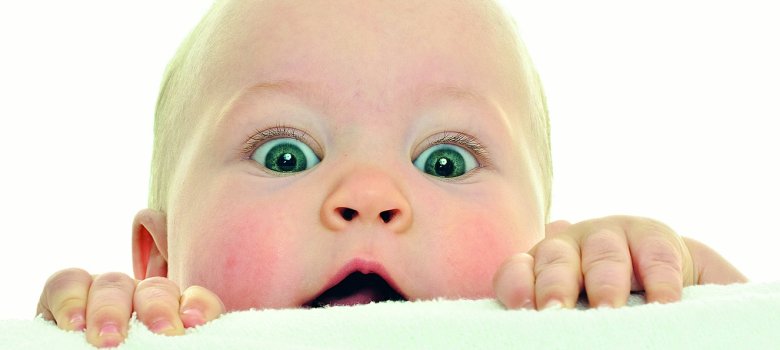Baby schaut neugierig über eine Schwelle