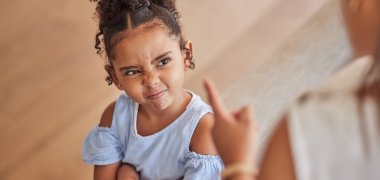 Angry child and tantrum discipline conflict for attitude problem in home with stressed mother. Young girl frustrated, unhappy and moody at disappointed adult punishment for negative behaviour. Angry child and tantrum discipline conflict for attitude problem in home with stressed mother. Young girl frustrated, unhappy and moody at disappointed adult punishment for negative behaviour.