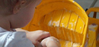 Ein Kind säubert den Spielzeug-LKW