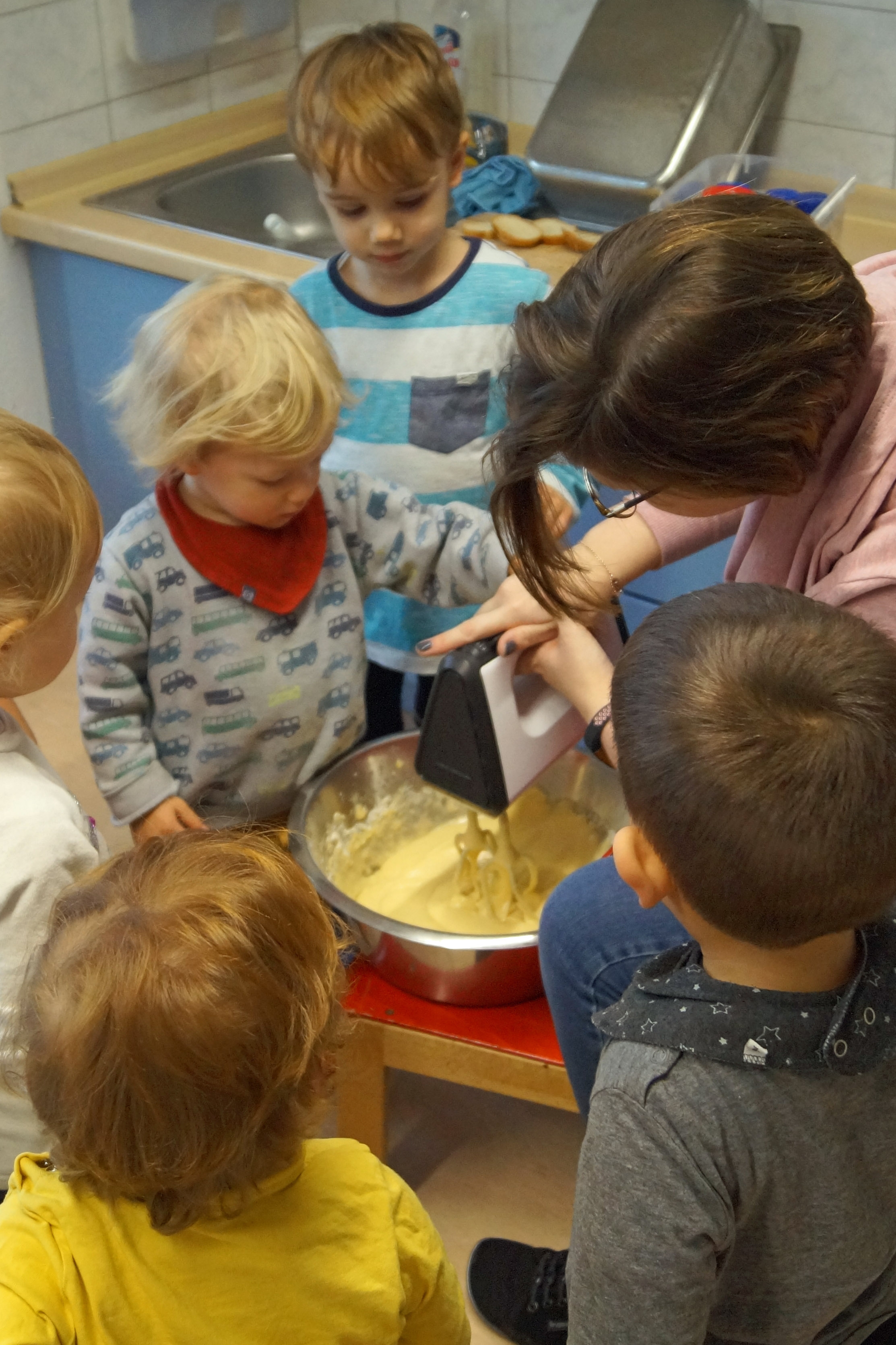 Kinder beobachten das Anrühren von Teig