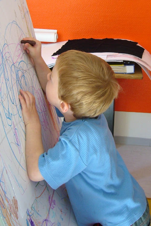 Ein Kind beim Malen auf einer Staffelei