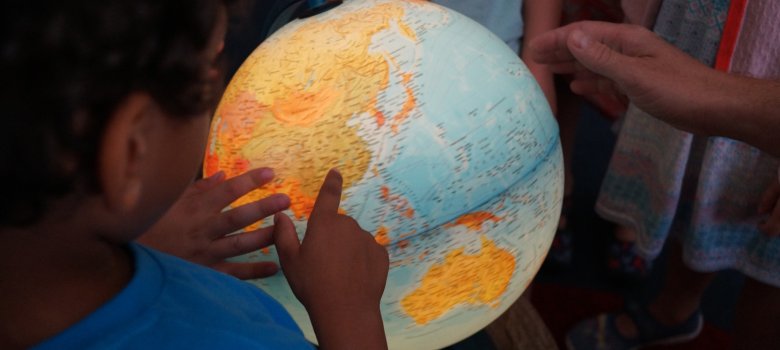 Kinder erkunden einen Globus