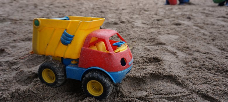 Ein Spielzeug-LKW im Sand