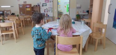 Zwei Kinder basteln an einem Tisch
