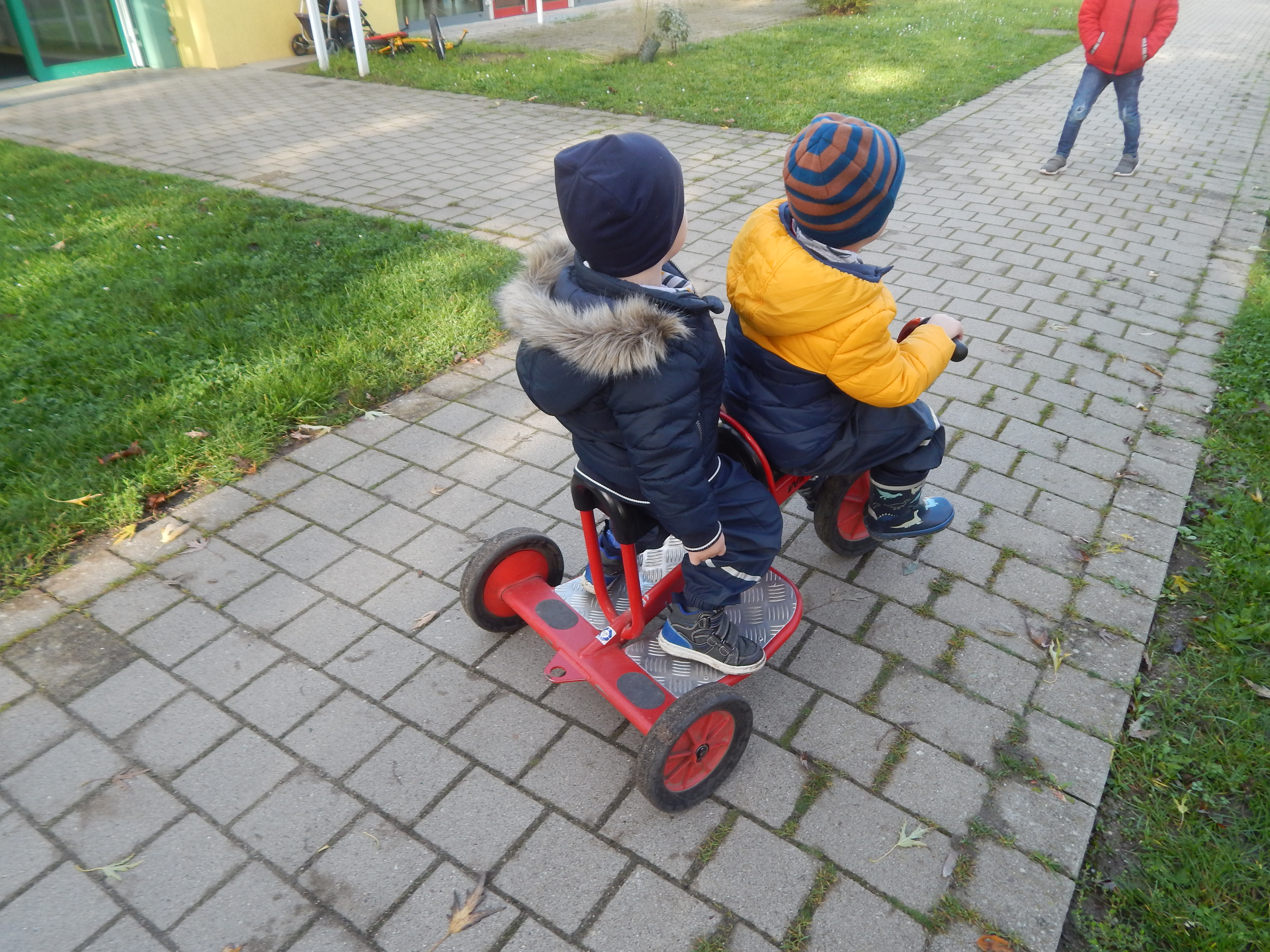 Kinder auf einem Dreirad