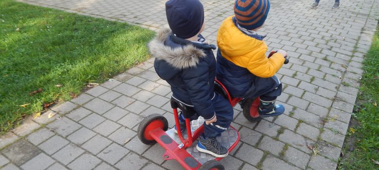 Kinder auf einem Dreirad