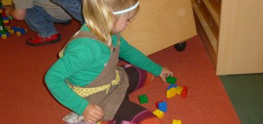 Ein Kind baut mit Stecksteinen