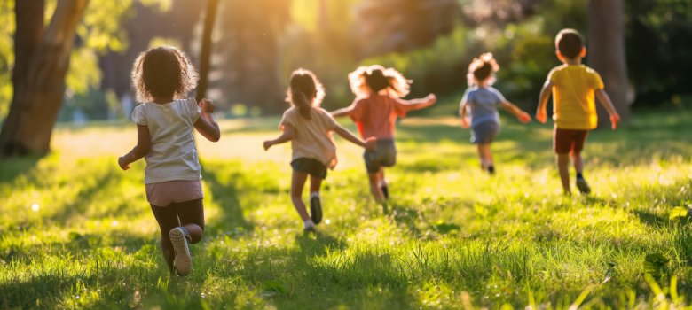 A group of diverse children play joyously in a sunlit park, running across the grass in a scene full of life and energy A group of diverse children play joyously in a sunlit park, running across the grass in a scene full of life and energy