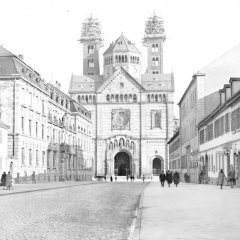 Blick über die Maximilianstraße zum Dom. An den Westtürmen finden Instandsetzungsarbeiten statt, die Turmspitzen sind eingerüstet. Links das Stadthaus, rechts der Laden für Damenhüte Ph. Dossinger, Aufnahme vom 2. November 1931.