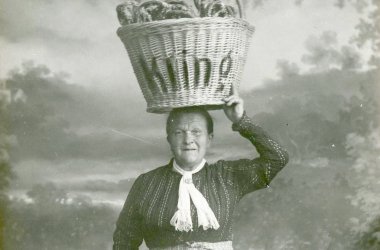 Die Brezelfrau Klaer der Speyerer Bäckerei Kling posiert für eine offizielle Werbepostkarte, 1910. Der sichere Transport des Brezelkorbs auf dem Kopf ist für sie scheinbar „Routine“.