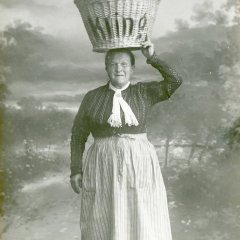 Die Brezelfrau Klaer der Speyerer Bäckerei Kling posiert für eine offizielle Werbepostkarte, 1910. Der sichere Transport des Brezelkorbs auf dem Kopf ist für sie scheinbar „Routine“.