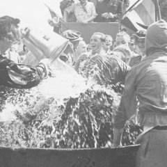 Die Speyerer Buchdrucker vollziehen beim Brezelfest 1936 einen alten Brauch: Das sog. Gautschen, bei dem ein Lehrling nach bestandener Abschlussprüfung in einer Bütte unter Wasser getaucht oder mit Wasser übergossen wird. 