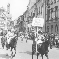 Die Reiter an der Spitze des Brezelfests-Umzugs von 1938 präsentierten das Motto dieses Festjahres: „Im Zeichen der neuen Rheinbrücke“.