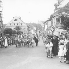 Der Festumzug mit Kindern als Fahnen- und Brezelträgern passiert die Gilgenstraße stadtauswärts, 1955.