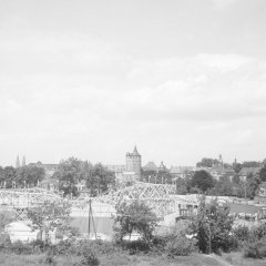 Blick über den Festplatz des Speyerer Brezelfests von 1958. Die weitläufige Achterbahn überragt den Festplatz, im Hintergrund die Speyerer Stadtsilhouette. 