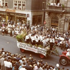 Eine der ersten Farbaufnahmen: Der Motivwagen durchquert die Maximilianstraße beim Brezelfest 1964 und thematisiert die Auflagen der GEMA im Kulturbereich. 
