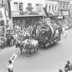 Der Brezelfest-Fassanstich, mit dem das Fest traditionell eröffnet wird, wird auf einem eigenen Motivwagen nachgestellt, der gerade durch die Maximilianstraße fährt, 1960.