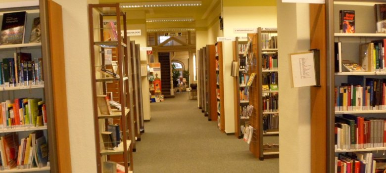 Blick durch einen Gang der Erwachsenenbibliothek Blick durch einen Gang der Erwachsenenbibliothek