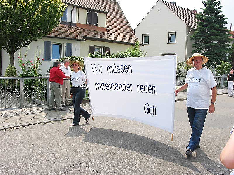 Mitglieder der Gemeinde mit Plakat "Wir müssen miteinander reden. Gott."