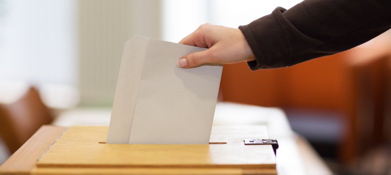 Stimmzettel in Wahlurne Stimmzettel in Wahlurne