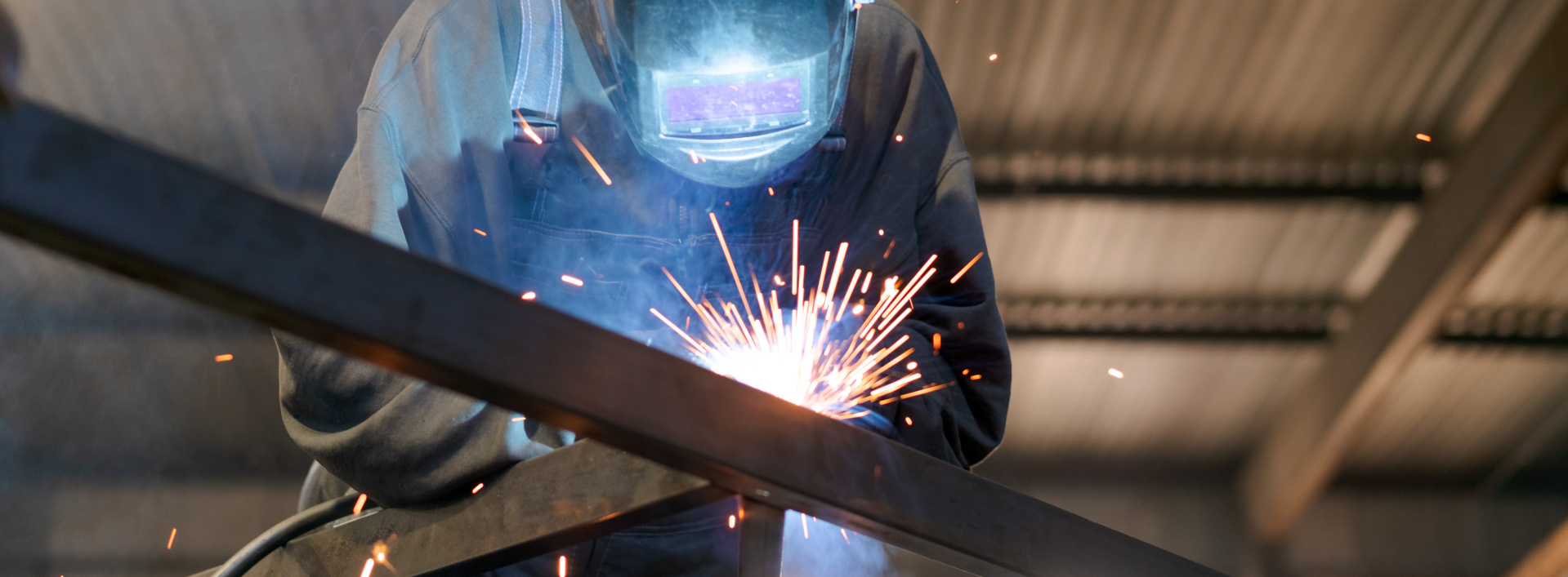 Welder Portrait with Glowing Mask and Sparks in Panoramic View