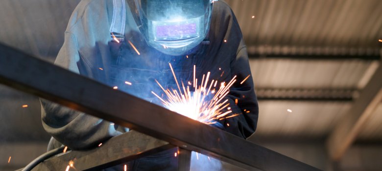 Welder Portrait with Glowing Mask and Sparks in Panoramic View
