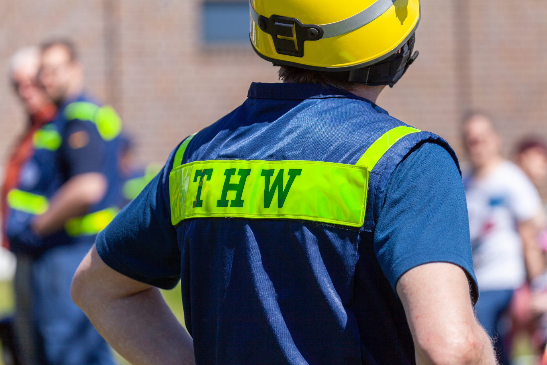 Deutsches Einsatzzeichen „THW“ auf der Warnweste eines Mannes. THW steht für „Technisches Hilfswerk“.