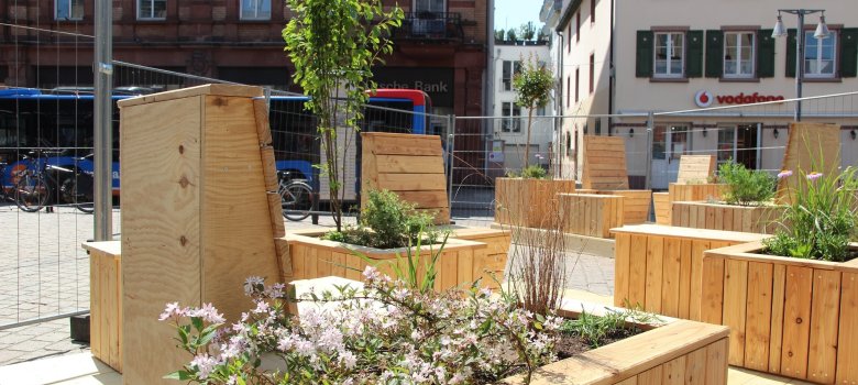 Sitzmöbel aus Holz mit bepflanzten Hochbeeten am Postplatz in Speyer