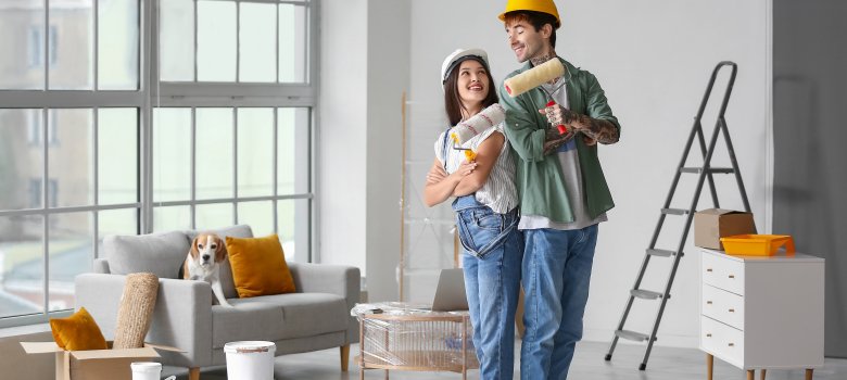 Young couple with paint rollers during repair in their new house